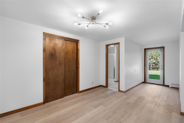 920 Mount Vernon Rd, Wurtsboro, NY 12790 - unfurnished bedroom with a chandelier, a baseboard heating unit, light wood-type flooring, and a closet
