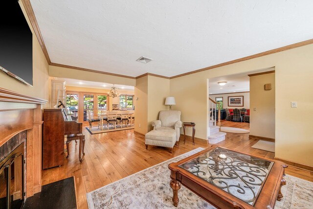 7 Hunter Ct, Dix Hills, NY 11746 - living area with ornamental molding, light wood-type flooring, a tiled fireplace, and a chandelier
