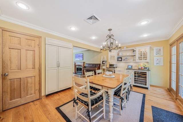 7 Hunter Ct, Dix Hills, NY 11746 - dining space with wine cooler, ornamental molding, a chandelier, light wood finished floors, and recessed lighting