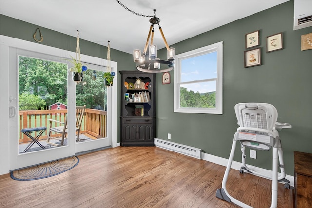 54 Graby Rd, Callicoon, NY 12723 - dining area featuring a baseboard heating unit, a chandelier, healthy amount of natural light, and wood finished floors