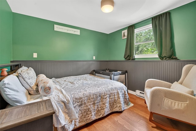 54 Graby Rd, Callicoon, NY 12723 - bedroom with a wainscoted wall, baseboard heating, and wood finished floors