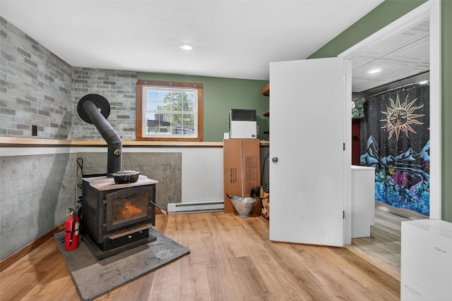 54 Graby Rd, Callicoon, NY 12723 - workout room featuring baseboard heating, wood finished floors, and a wood stove