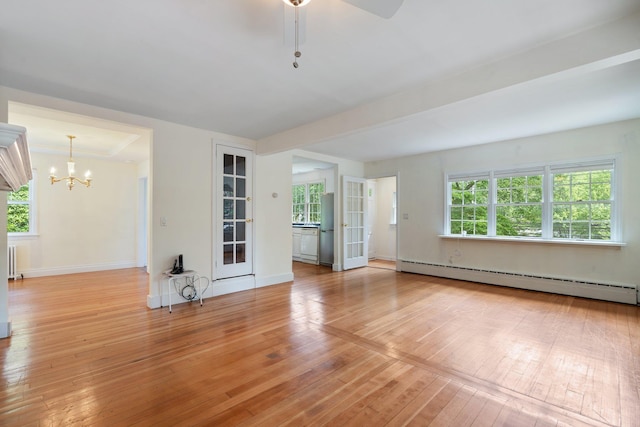 1459 N Country Rd, Wading River, NY 11792 - unfurnished living room featuring baseboard heating, light wood-style floors, healthy amount of natural light, and a chandelier