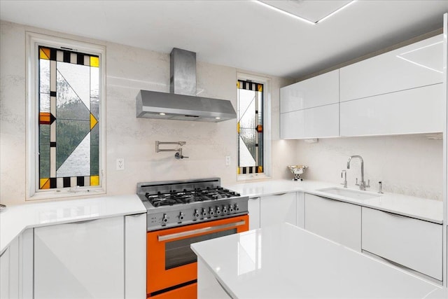 544 Oxford Rd, Cedarhurst, NY 11516 - kitchen featuring wall chimney range hood, stainless steel stove, white cabinetry, and healthy amount of natural light