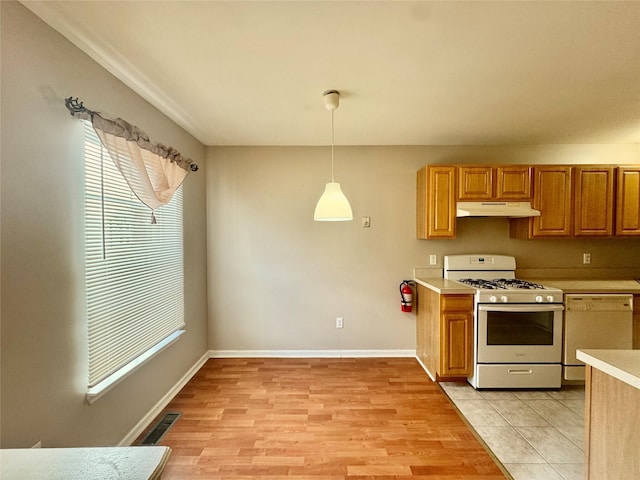 71 Jordan Ln, Middletown, NY 10940 - kitchen with white appliances, under cabinet range hood, light countertops, pendant lighting, and light wood-style floors
