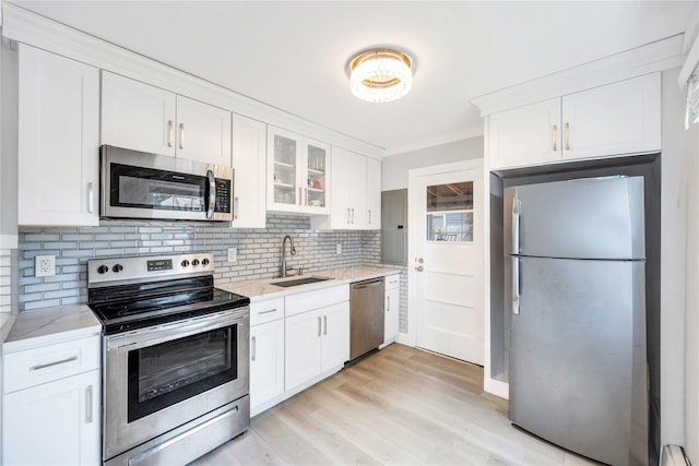 63 Old Farm Rd, Levittown, NY 11756 - kitchen with appliances with stainless steel finishes, white cabinets, backsplash, glass insert cabinets, and ornamental molding
