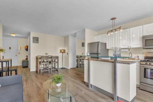 345 E 93rd St Unit 2E, New York Manhattan, NY 10128 - kitchen with appliances with stainless steel finishes, white cabinetry, light wood-type flooring, and a center island