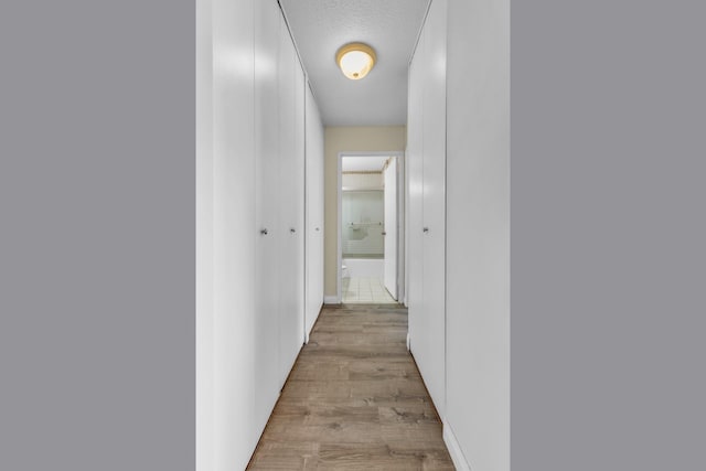 345 E 93rd St Unit 2E, New York Manhattan, NY 10128 - corridor featuring light wood-style flooring and a textured ceiling