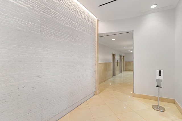 345 E 93rd St Unit 2E, New York Manhattan, NY 10128 - hallway with brick wall, a wainscoted wall, light tile patterned flooring, and recessed lighting