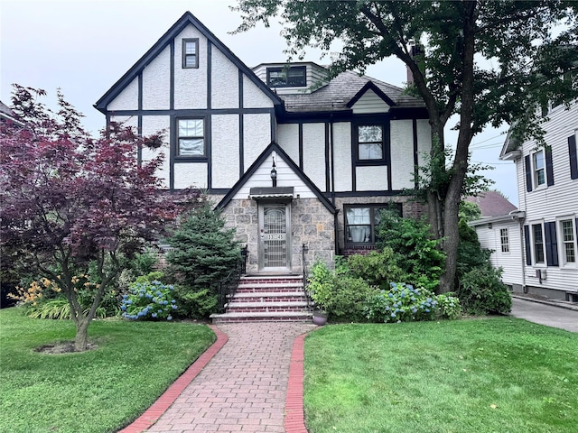 3345 160th St, Flushing, NY 11358 - tudor house featuring a front lawn, stucco siding, and stone siding