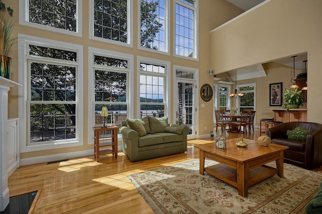 90 River Rd, Hyde Park, NY 12538 - living room featuring wood finished floors, a towering ceiling, and a chandelier