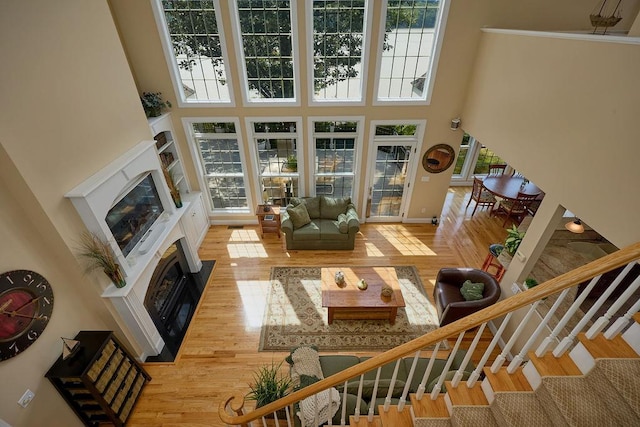 90 River Rd, Hyde Park, NY 12538 - living room featuring a fireplace, a high ceiling, wood finished floors, and stairs