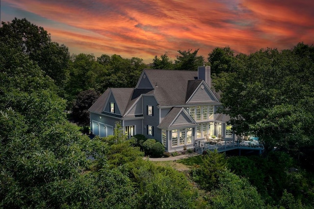 90 River Rd, Hyde Park, NY 12538 - back of house at dusk featuring a chimney and an attached garage