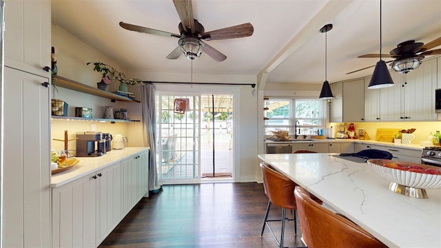 114 Shetland Dr, New City, NY 10956 - kitchen with a ceiling fan, dark wood finished floors, light stone counters, decorative light fixtures, and a breakfast bar