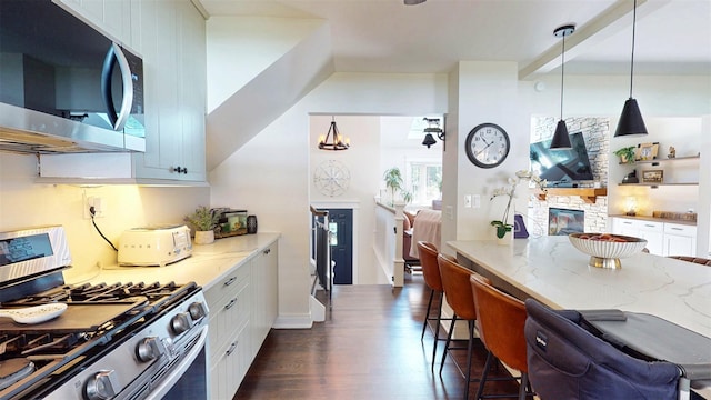 114 Shetland Dr, New City, NY 10956 - kitchen featuring stainless steel appliances, light stone countertops, a breakfast bar, and white cabinets