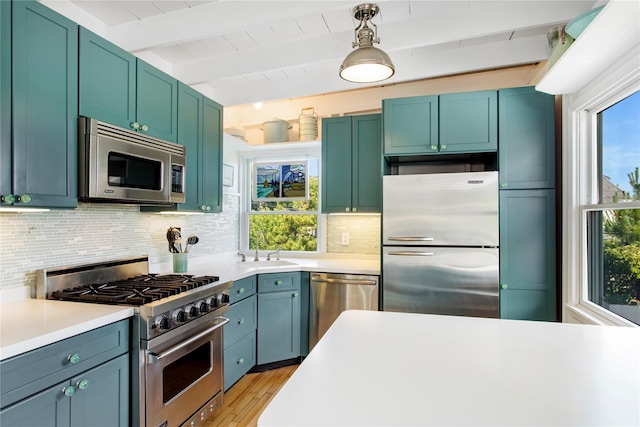 230 Bay Walk, Fire Island Pines, NY 11782 - kitchen featuring appliances with stainless steel finishes, beamed ceiling, tasteful backsplash, light countertops, and light wood-type flooring