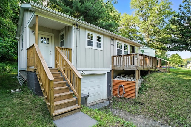 7 Fayer Ct, Phillipsport, NY 12790 - back of house featuring board and batten siding, driveway, an attached garage, a wooden deck, and a lawn