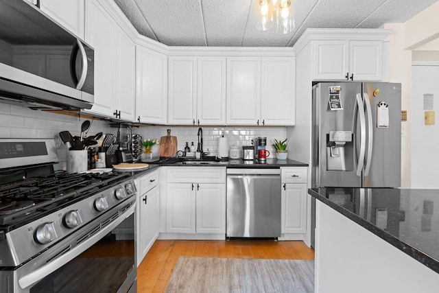 3220 Fairfield Ave Unit 6A, Bronx, NY 10463 - kitchen featuring appliances with stainless steel finishes, light wood-type flooring, white cabinets, and backsplash