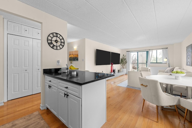 3220 Fairfield Ave Unit 6A, Bronx, NY 10463 - kitchen with open floor plan, light wood-style floors, white cabinets, and dark countertops