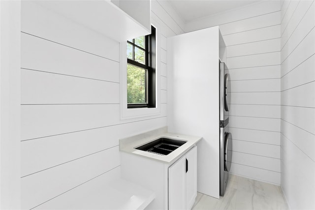 7 Rosemary Ln, Sag Harbor, NY 11963 - washroom featuring stacked washing machine and dryer and light marble finish floors