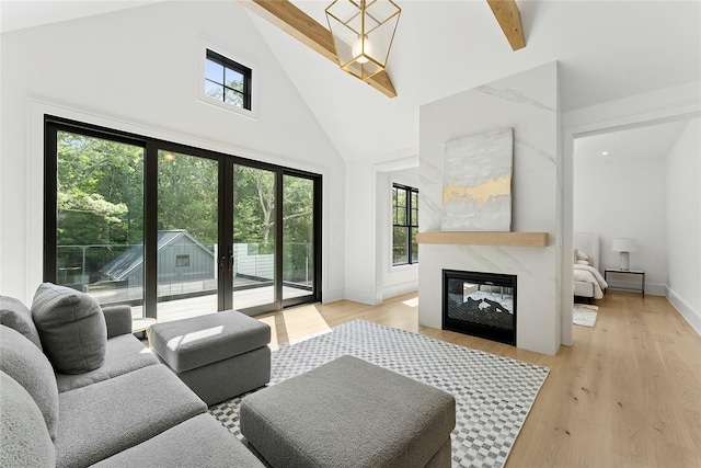 7 Rosemary Ln, Sag Harbor, NY 11963 - living area with high vaulted ceiling, plenty of natural light, a high end fireplace, light wood-style floors, and beamed ceiling