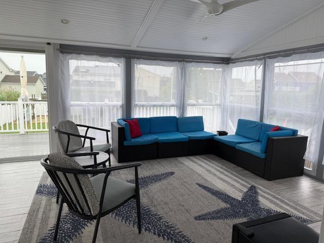 881 Surf St, Lindenhurst, NY 11757 - sunroom with lofted ceiling, a deck, and wood finished floors