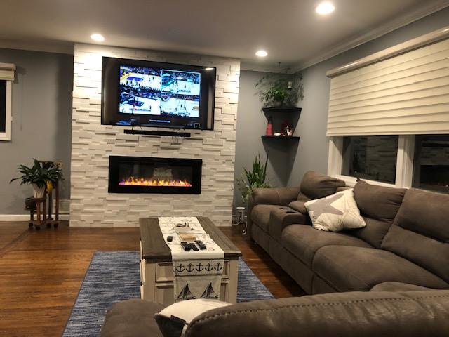 881 Surf St, Lindenhurst, NY 11757 - living area with a fireplace, crown molding, wood finished floors, and recessed lighting