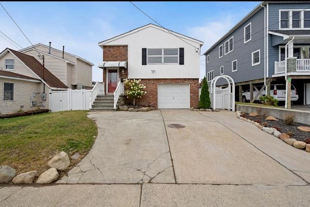 881 Surf St, Lindenhurst, NY 11757 - view of front of property with brick siding, concrete driveway, and an attached garage