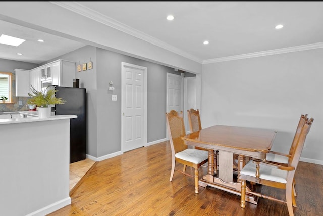 881 Surf St, Lindenhurst, NY 11757 - dining space featuring light wood finished floors, recessed lighting, and ornamental molding