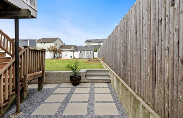 881 Surf St, Lindenhurst, NY 11757 - fenced backyard featuring a playground, a shed, a patio area, and stairs