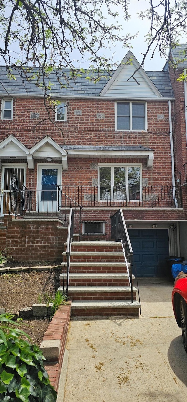 5203 72nd Pl, Maspeth, NY 11378 - townhome / multi-family property featuring brick siding, concrete driveway, a garage, and stairs