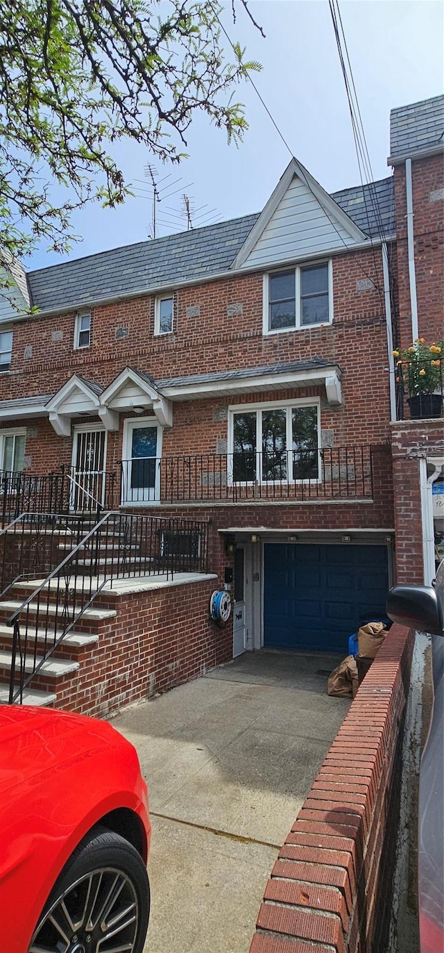 5203 72nd Pl, Maspeth, NY 11378 - view of property with a garage, brick siding, and concrete driveway