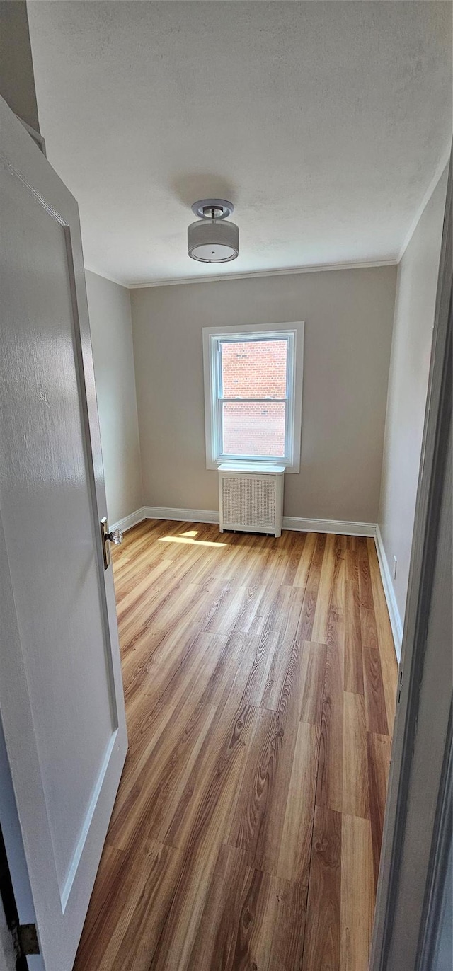 5203 72nd Pl, Maspeth, NY 11378 - empty room featuring radiator and wood finished floors