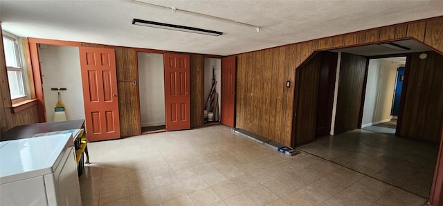 5203 72nd Pl, Maspeth, NY 11378 - empty room featuring wooden walls, a textured ceiling, tile patterned floors, and washer and clothes dryer