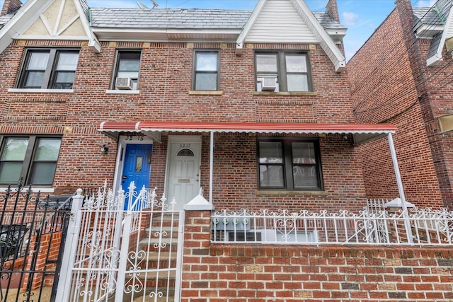 32-17 110, East Elmhurst, NY 11369 - view of front of home with brick siding, a fenced front yard, and cooling unit