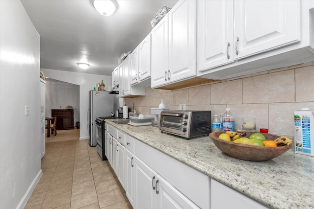 32-17 110, East Elmhurst, NY 11369 - kitchen with gas stove, white cabinetry, backsplash, light tile patterned floors, and light stone counters