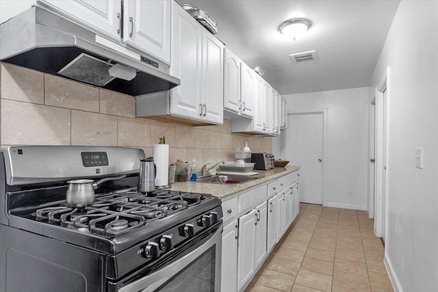 32-17 110, East Elmhurst, NY 11369 - kitchen featuring stainless steel range with gas cooktop, under cabinet range hood, white cabinets, decorative backsplash, and light countertops