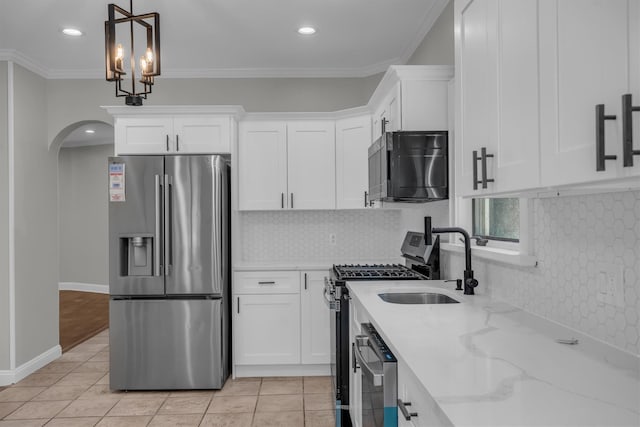 643 Deer Park Ave, Babylon, NY 11702 - kitchen featuring stainless steel appliances, white cabinets, light stone counters, arched walkways, and backsplash