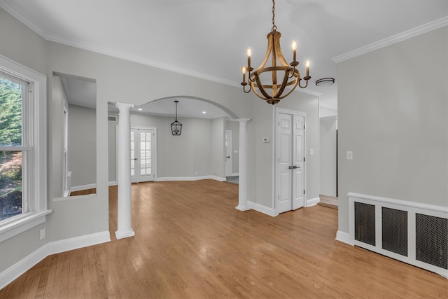 643 Deer Park Ave, Babylon, NY 11702 - unfurnished room with decorative columns, arched walkways, a chandelier, light wood finished floors, and healthy amount of natural light