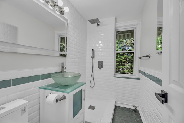 643 Deer Park Ave, Babylon, NY 11702 - bathroom with tile walls, a tile shower, tile patterned floors, and vanity