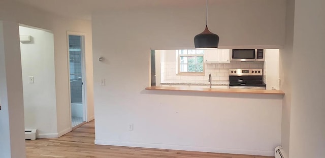 190 Union St, Poughkeepsie, NY 12601 - kitchen featuring appliances with stainless steel finishes, a baseboard radiator, wood finished floors, backsplash, and hanging light fixtures