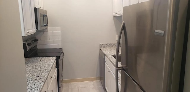 190 Union St, Poughkeepsie, NY 12601 - kitchen featuring appliances with stainless steel finishes, white cabinetry, light stone counters, tasteful backsplash, and light tile patterned floors