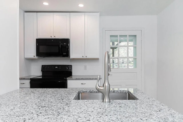 5 Jefferson St, Poughkeepsie, NY 12601 - kitchen with black appliances, white cabinetry, light stone counters, and recessed lighting