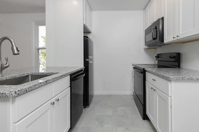 5 Jefferson St, Poughkeepsie, NY 12601 - kitchen with black appliances, white cabinets, and light stone countertops