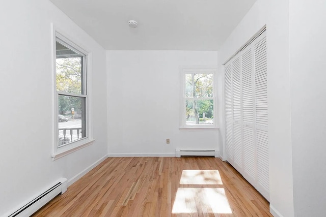5 Jefferson St, Poughkeepsie, NY 12601 - unfurnished bedroom with a baseboard heating unit, light wood-style floors, and a closet