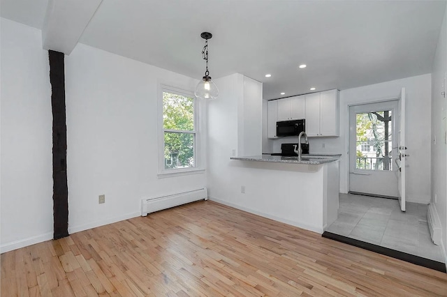 5 Jefferson St, Poughkeepsie, NY 12601 - kitchen featuring black microwave, a baseboard heating unit, light wood finished floors, white cabinets, and recessed lighting