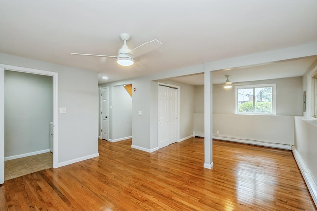 24 Hickory St, Deer Park, NY 11729 - below grade area with a ceiling fan, a baseboard heating unit, and light wood finished floors