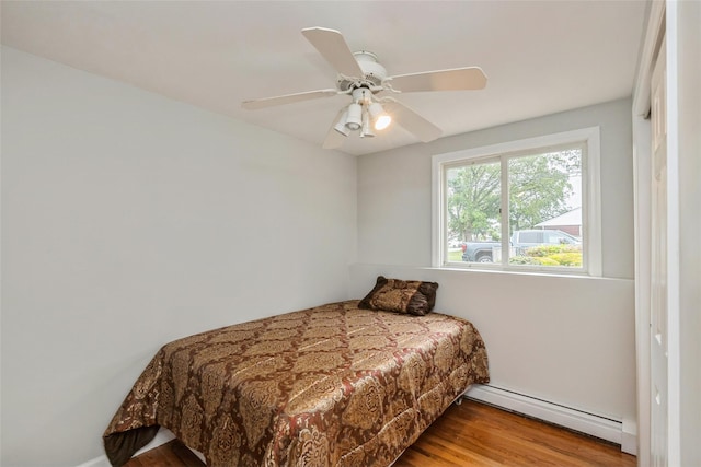 24 Hickory St, Deer Park, NY 11729 - bedroom with a baseboard radiator, wood finished floors, and a ceiling fan