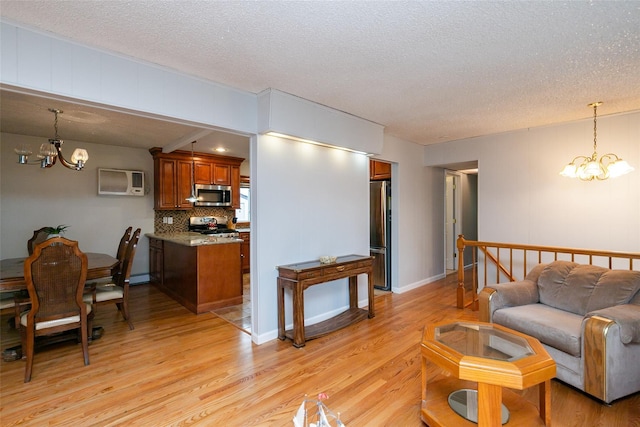 24 Hickory St, Deer Park, NY 11729 - living area featuring a chandelier, light wood-style floors, a textured ceiling, and a wall unit AC