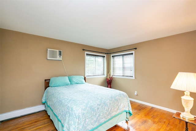 24 Hickory St, Deer Park, NY 11729 - bedroom with a baseboard heating unit, a wall mounted air conditioner, and wood finished floors